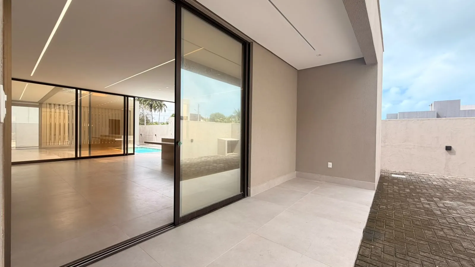 Living com portas de vidro para a piscina